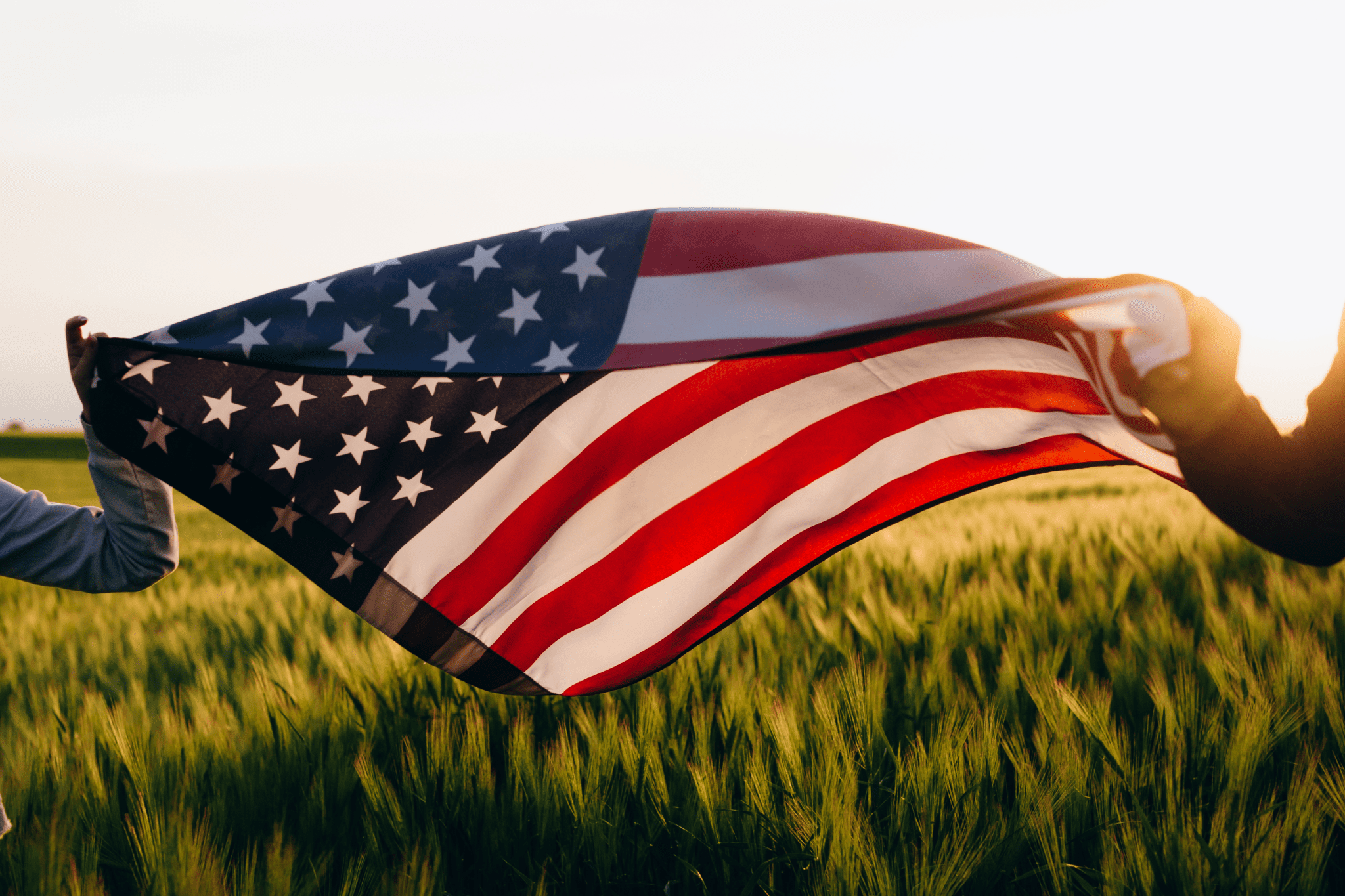 j2 A flag flying in the wind over a field.