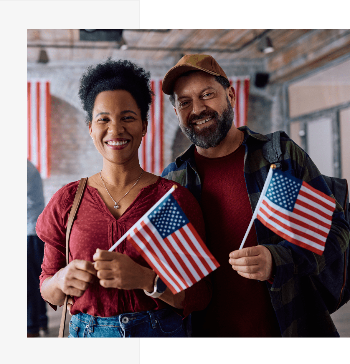 k1 A man and woman holding american flags in front of the flag.